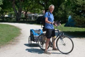 ein Mann hat einen Fahrradanhänger für Hunde an seinem Fahrrad