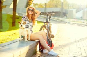 eine Frau fährt mit ihrem Hund Fahrrad